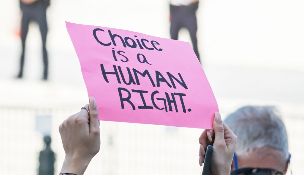 Woman holding Choice is a Human right placard sign at protest