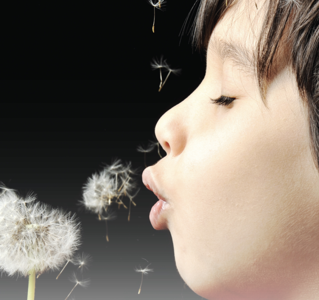 2022 Annual report featured image child blowing dandelion seeds